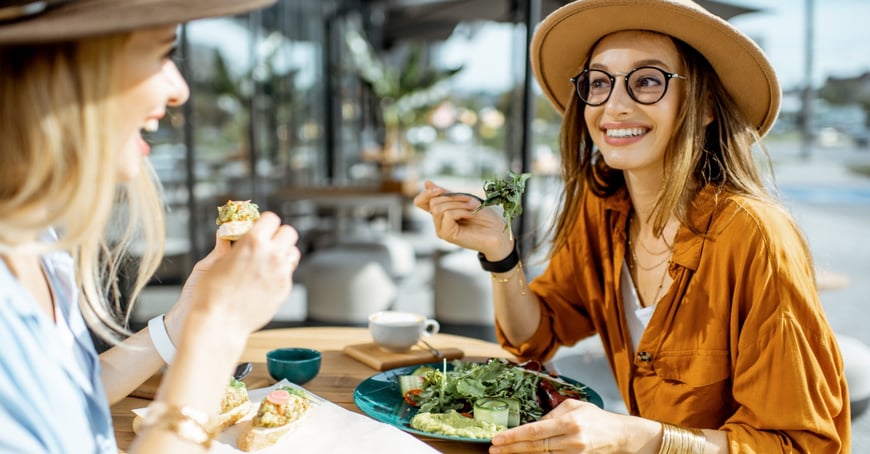 Two women eating a salad in JLT restaurant