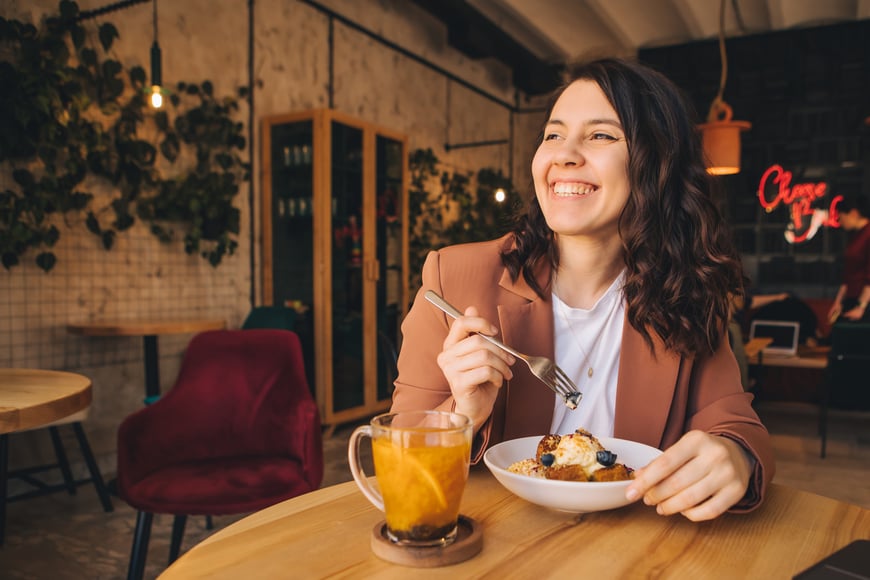 Woman eating bread pudding in restaurant