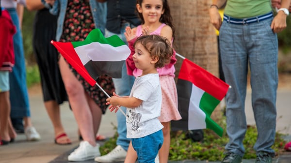baby holding a uae flag