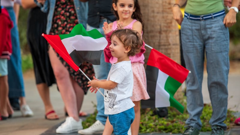 baby holding a uae flag