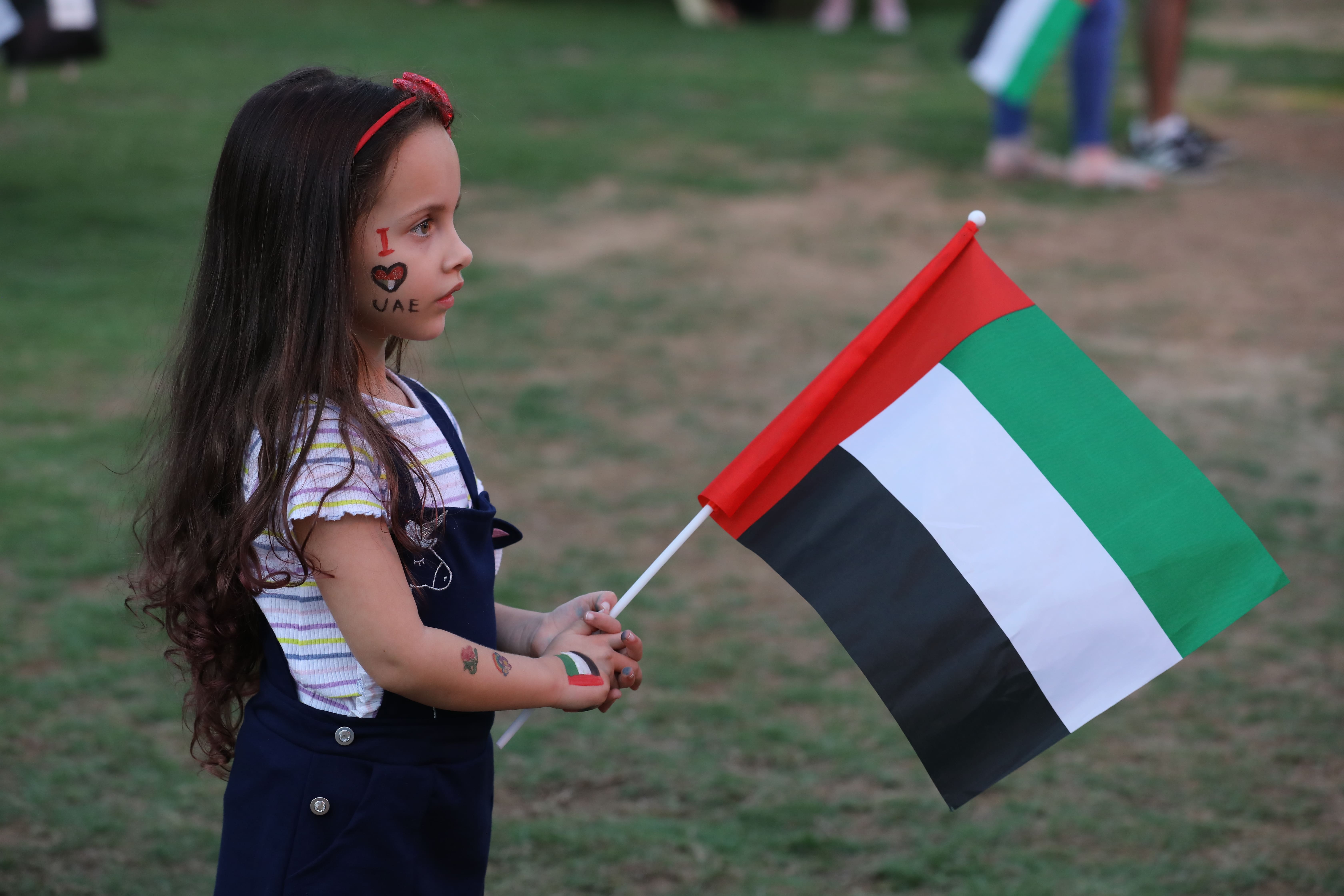 Girl holding the flag of the UAE